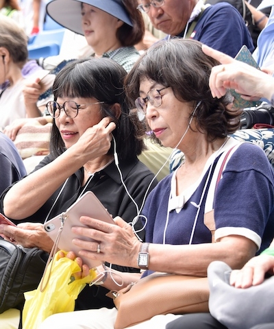 チアホンで解説を聞く参加者たち